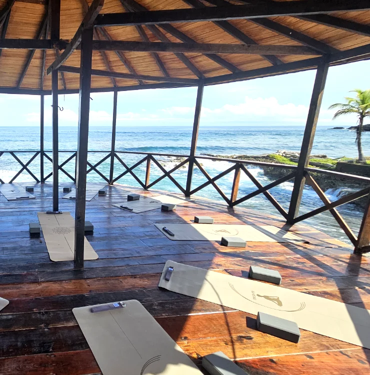 Open-air yoga shala and deck overlooking the ocean at Brisa Bahía retreat center.