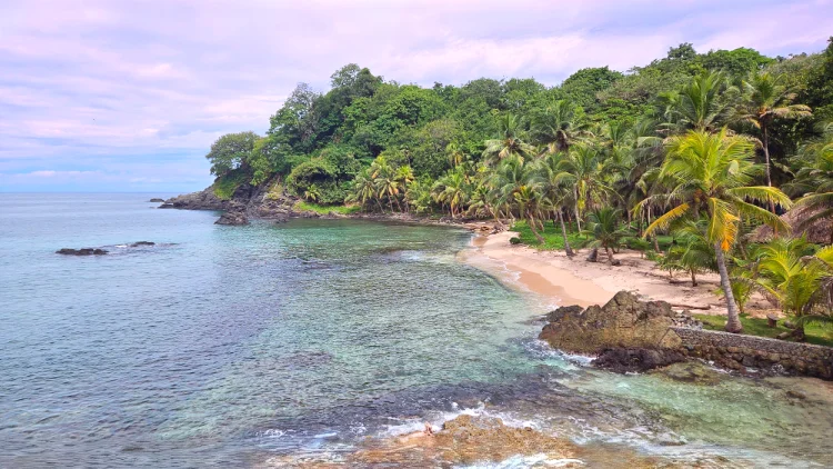 Private beach with clear water and tropical coastline at Brisa Bahía retreat center.